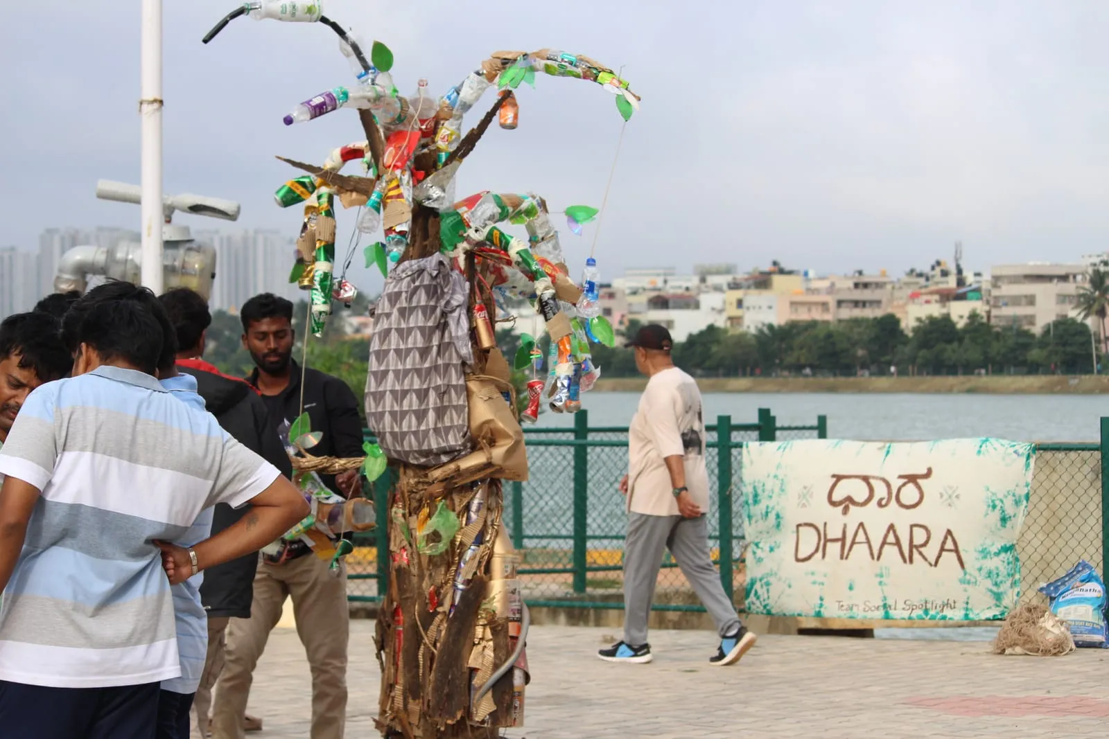 Volunteers beside a Dhaara sign at a Bengaluru lake