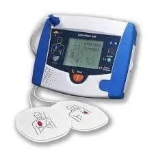 A portable AED with its two electrode pads, each printed with a diagram showing where it goes on the chest
