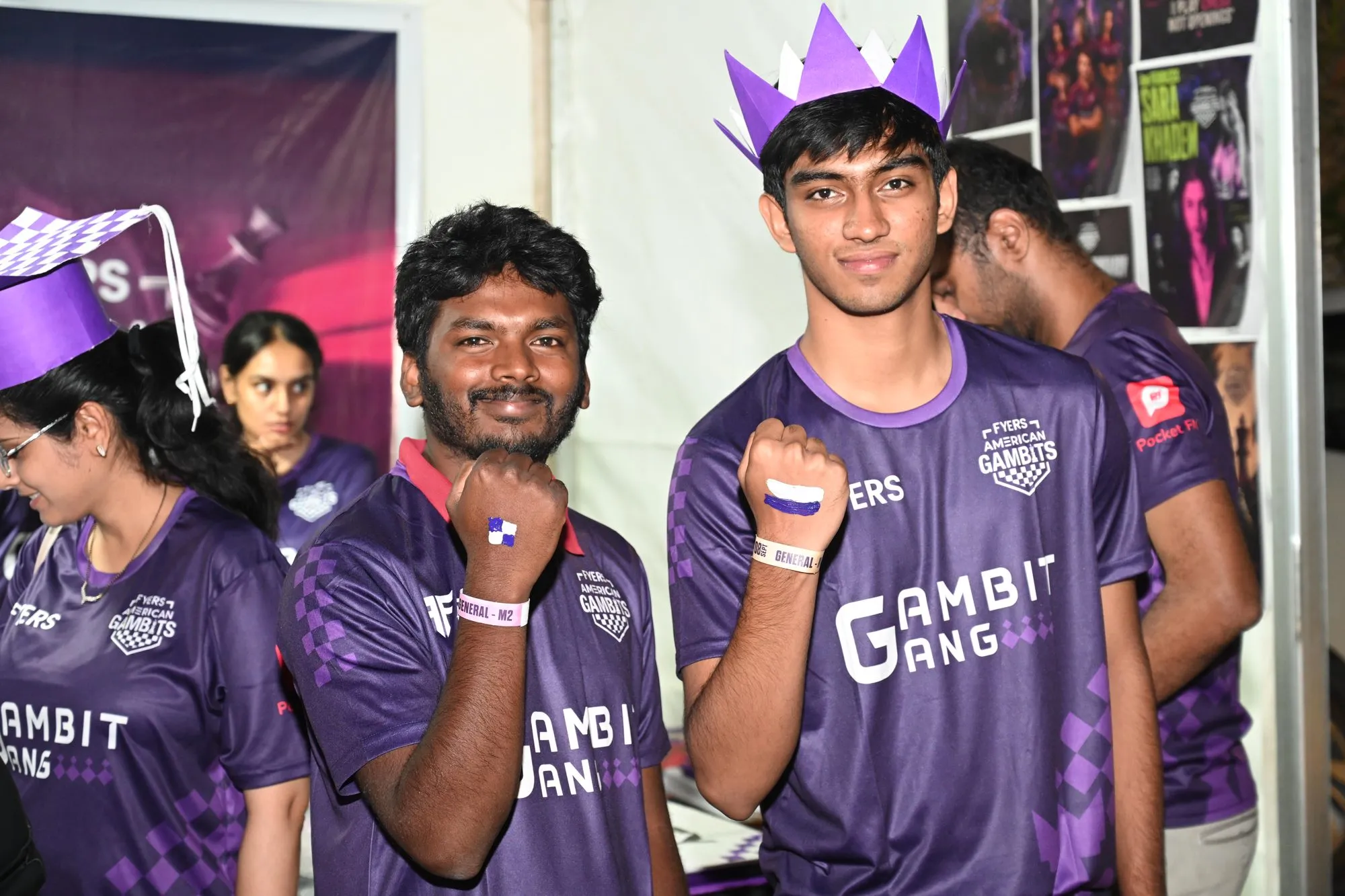 Volunteers in paper crowns showing chessboard squares painted on their fists