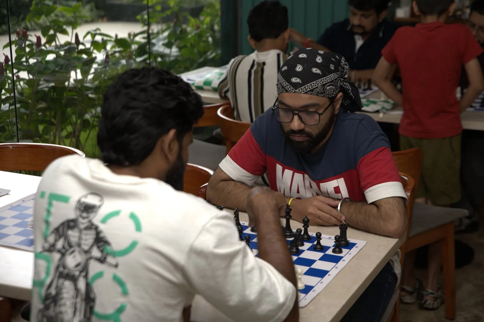 Two volunteers playing chess at a café table during the orientation meetup