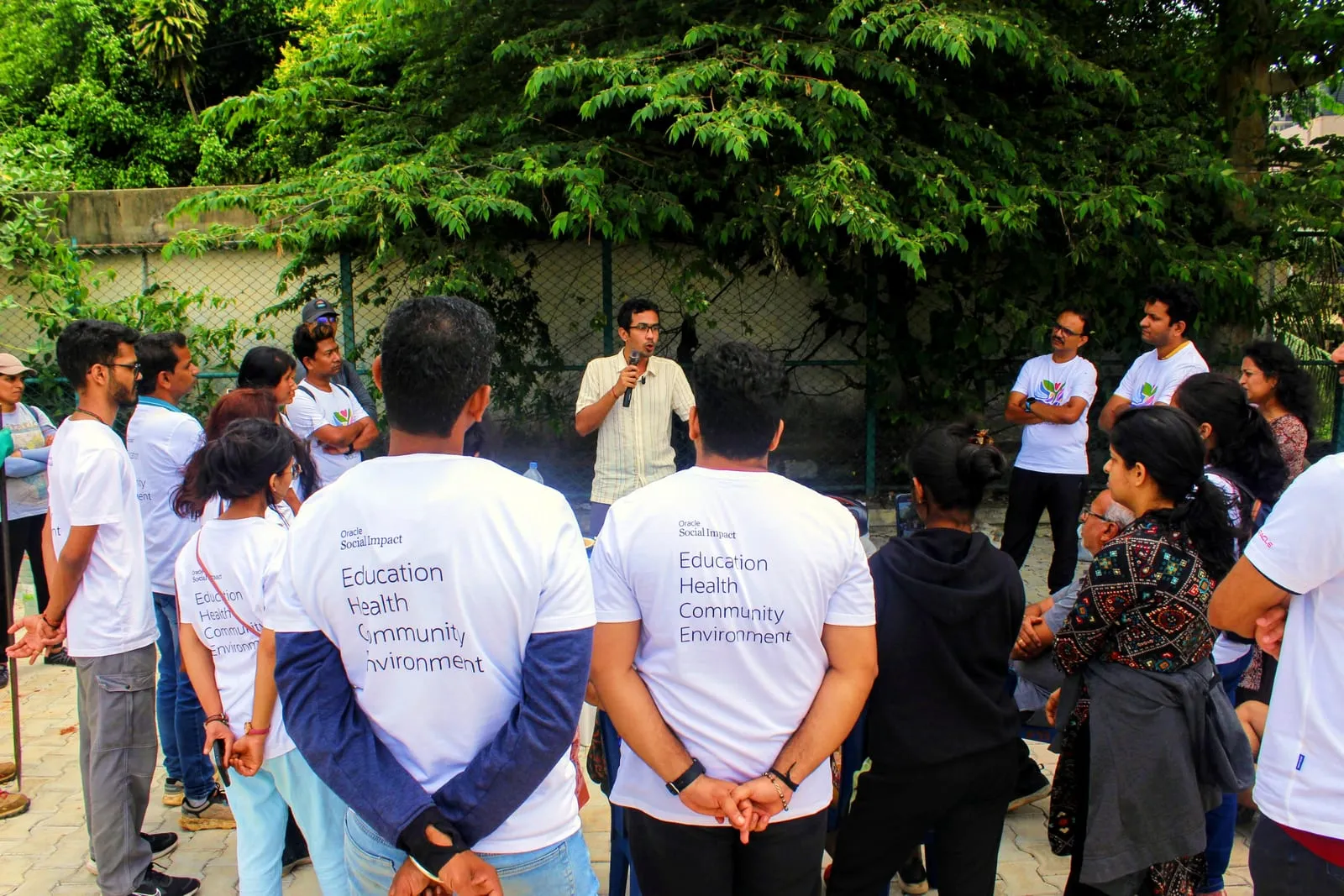 College students in white volunteer T-shirts gathered in a park in Bengaluru for a briefing