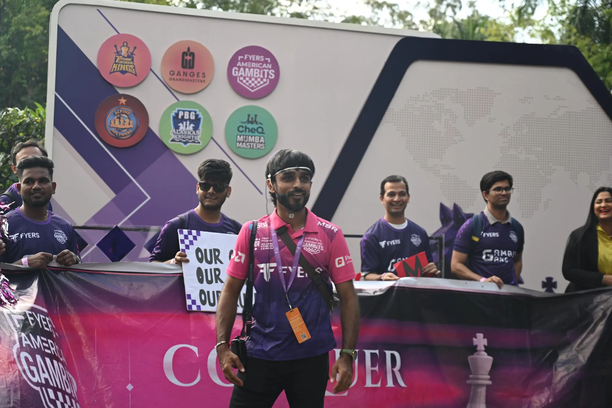 A coordinator in a pink jersey in front of the Gambits Gang banner line